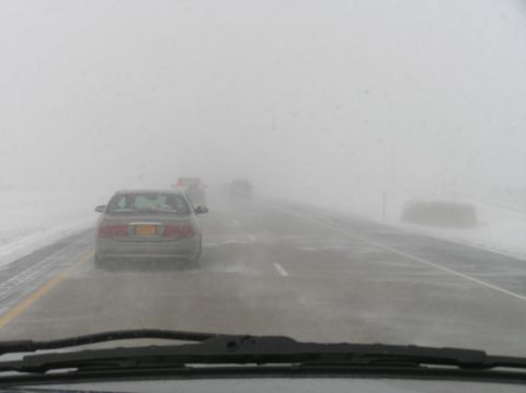 2000 Ford Excursion - Multiple vehicles navigate a highway obscured by dense fog and blowing snow.