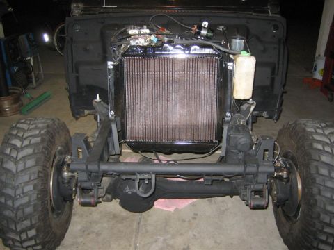 1987 Suzuki Samurai - Front end of a 1987 Suzuki Samurai showing the axle, radiator, and engine bay components during installation.