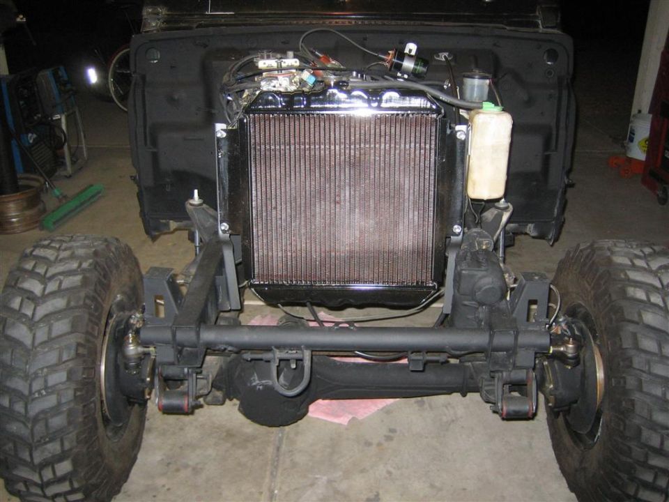 1987 Suzuki Samurai front axle, suspension, and radiator assembly. The vehicle is partially disassembled
