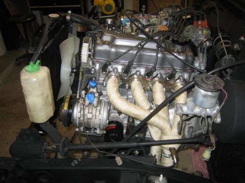 1987 Suzuki Samurai - Engine assembly with visible components like the exhaust manifold, coolant reservoir, and fan, suggesting it is out of a vehicle.
