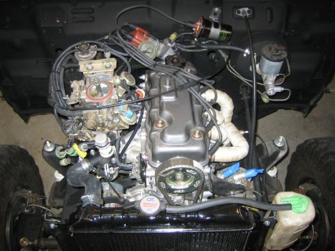 1987 Suzuki Samurai - The engine bay of a vehicle, the engine, carburetor, and radiator. Text visible on the radiator cap and a watermark.