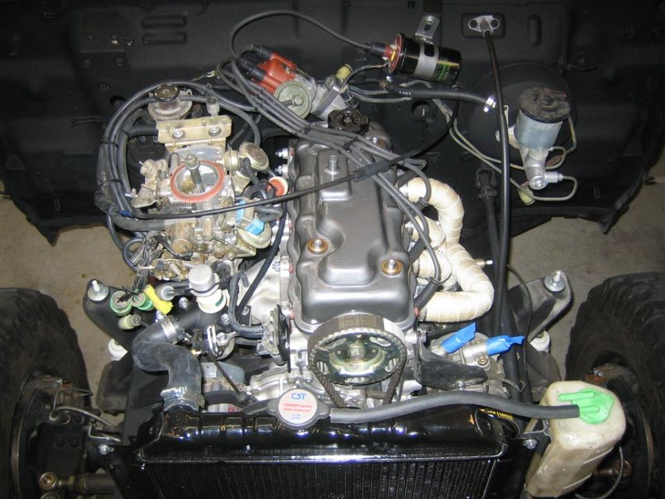 Engine bay with engine and carburetor. Visible text includes 'CST' and 'SUPERMOTORS'