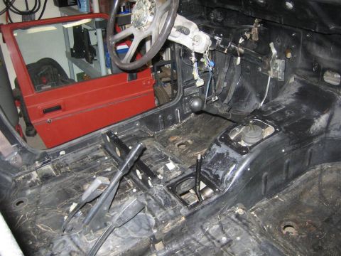 1987 Suzuki Samurai - Interior of a 1987 Suzuki Samurai undergoing restoration, with the floor pan and dashboard exposed.