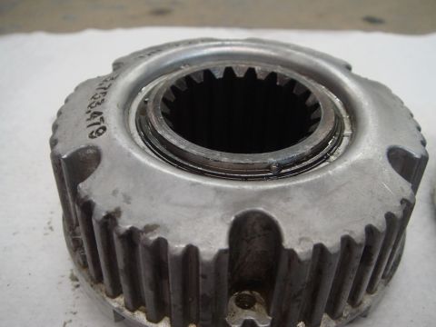 1996 Ford Bronco - A close-up shows a metal manual locking hub with visible teeth and a stamped part number.