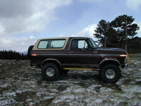 1979 Ford Bronco - Side view of a brown Ford Bronco with a tan top, parked in a snowy, outdoor landscape.