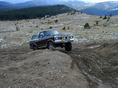 1979 Ford Bronco - This 1979 Ford Bronco is navigating a challenging dirt trail in a mountainous landscape.