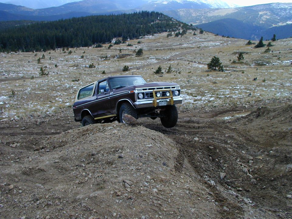 1979 Ford Bronco climbing a dirt hill off-road