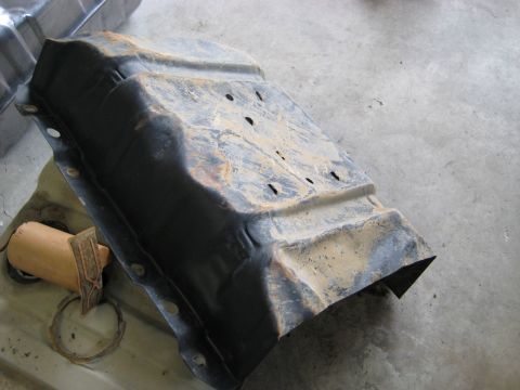 1996 Ford Bronco - A detached, weathered fuel tank sits on a concrete surface, showing signs of rust and wear.