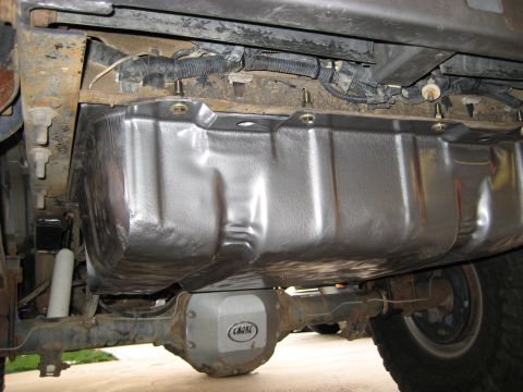1996 Ford Bronco - The underside of a vehicle reveals a freshly installed fuel tank and a Currie-branded rear axle assembly.
