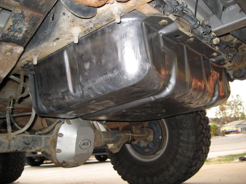 1996 Ford Bronco - Close-up view of the undercarriage, highlighting a shiny fuel tank and a rear axle assembly with a distinctive logo.