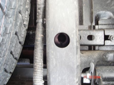 1981 Ford Bronco - Detail shot of a vehicle's undercarriage, showing structural components and a tire.