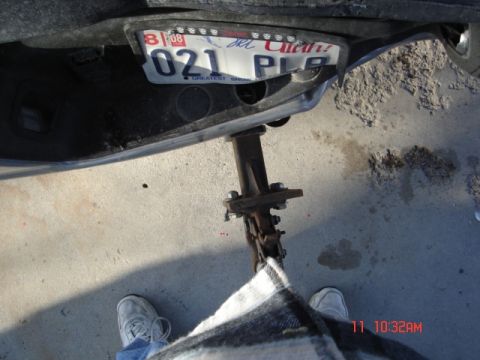 1981 Ford Bronco - Close-up of a vehicle's rear bumper, showing a license plate and a jack.