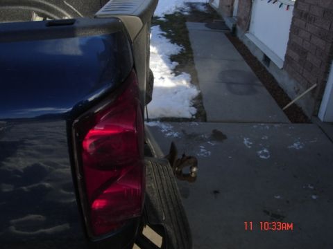1981 Ford Bronco - The rear of a dark-colored pickup truck is shown parked next to a house with snow on the ground.