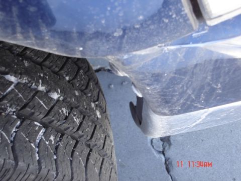 1981 Ford Bronco - Close-up of a blue vehicle's fender and tire, with snow visible on the tire tread. A timestamp indicates 11:11 AM.