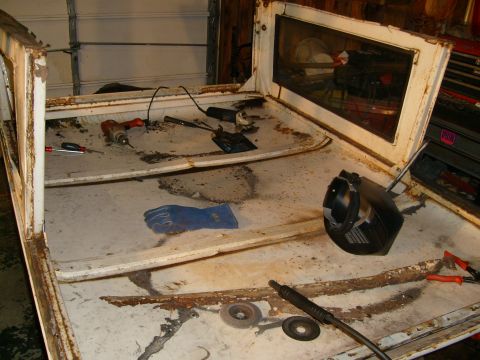 1974 Ford Bronco - Tools and safety gear are laid out on the interior of a heavily rusted vehicle body.