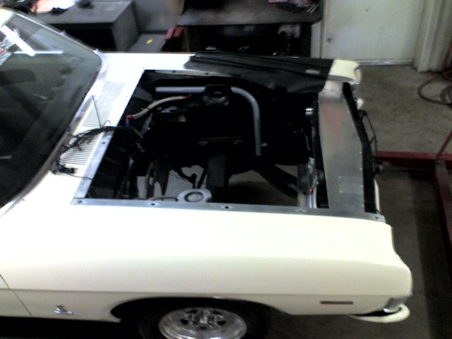 White 1963 Ford Fairlane with hood open, showing engine bay and radiator. Front view