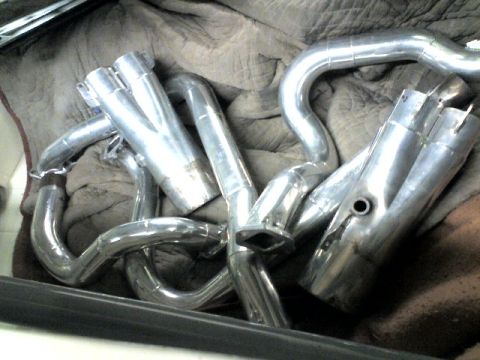 1963 Ford Fairlane - A set of chrome exhaust headers are laid out on a cloth surface, ready for installation.