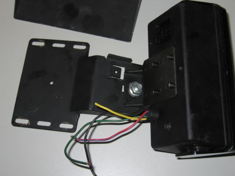 2001 Ford Crown Victoria - Close-up of a black electronic component with exposed wires and a metal mounting bracket.