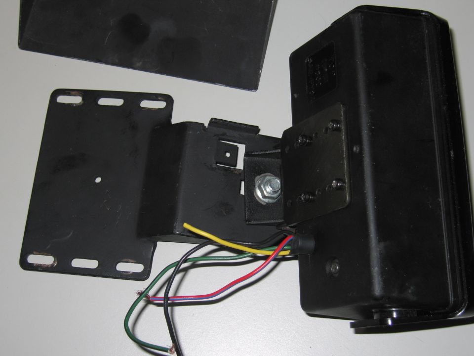 Black metal bracket assembly with wires connected to a black box