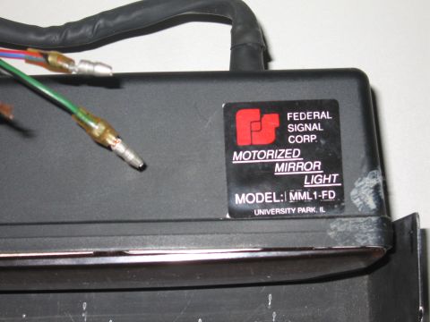 2001 Ford Crown Victoria - Close-up of a Federal Signal Corp. motorized mirror light module with wiring connectors.