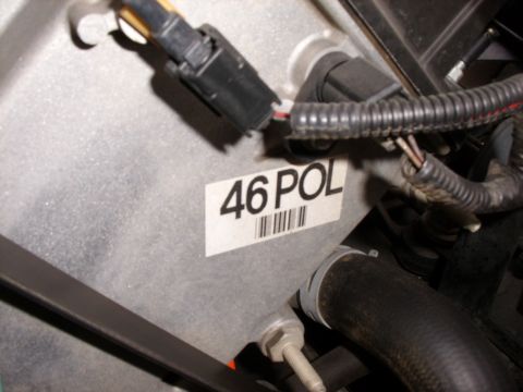 2005 Ford Crown Victoria - A close-up view of an engine component a label with '46 POL' and a barcode.