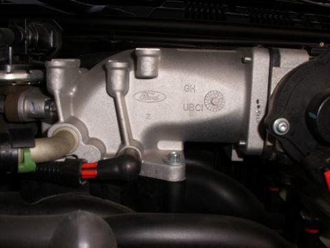 2005 Ford Crown Victoria - A close-up view of a Ford throttle body, showing its intricate design and part markings.