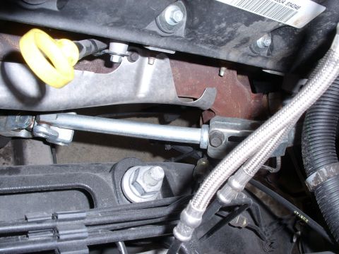 2005 Ford Crown Victoria - Close-up view of engine parts, showing exhaust manifold and linkage system.