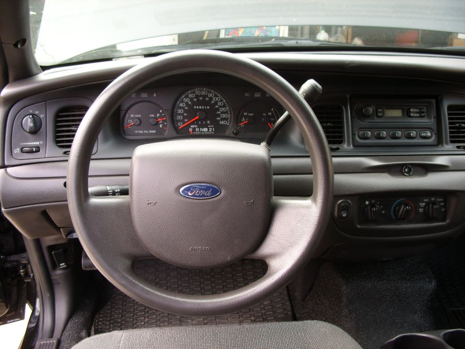 Ford sedan dashboard with steering wheel, gauge cluster, radio and HVAC controls