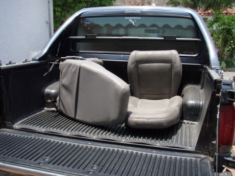 1995 Ford F-150 - The rear of a 1995 Ford F-150 pickup truck shows two seats loaded in the bed.