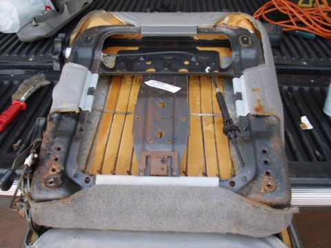 1995 Ford F-150 - Close-up view of a disassembled car seat, showing the metal frame and internal padding.