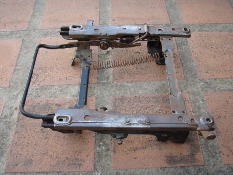 1995 Ford F-150 - Seat frame mechanism, likely from an older vehicle, photographed on a tiled surface.