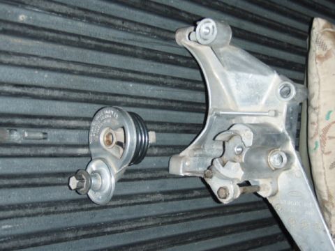 1995 Ford F-150 - Close-up of a belt tensioner and its mounting bracket, likely a vehicle part.