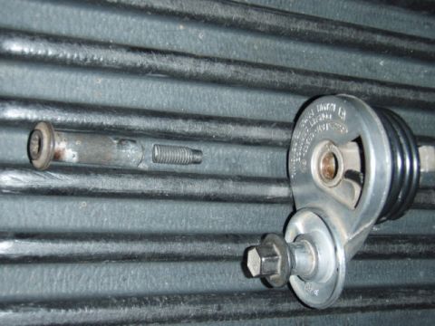 1995 Ford F-150 - Close-up of a belt tensioner pulley and mounting hardware, likely from a vehicle's engine bay.
