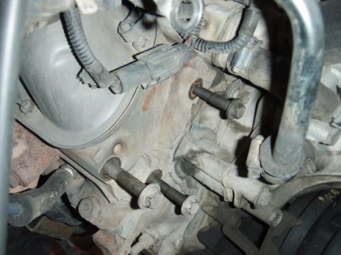 1995 Ford F-150 - Close-up view of engine components, showing bolts and wiring harnesses.