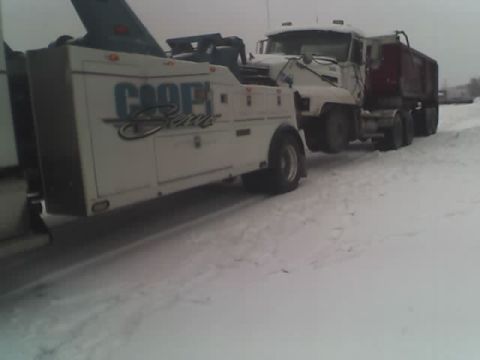 1992 Ford Bronco - A tow truck is seen towing a dump truck through a snowy landscape.
