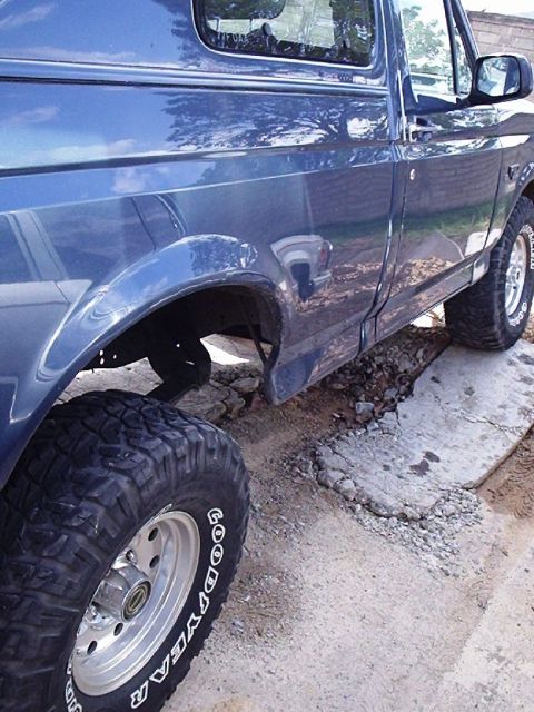 1995 Ford F-150 - This 1995 Ford F-150 pickup truck is shown from the side, its large off-road tires.