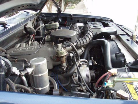 1995 Ford F-150 - The engine bay of a 1995 Ford F-150 shows its V8 engine, alternator, and battery.