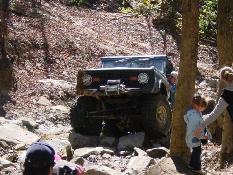 1976 Ford Bronco - This 1976 Ford Bronco is shown tackling a challenging off-road course with its front end prominently displayed.