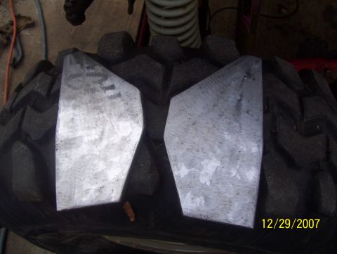 1978 Ford Bronco - Two metal plates are placed on a tire, obscuring the tread pattern.