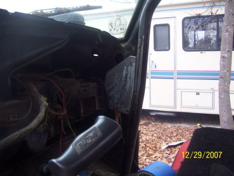 1978 Ford Bronco - Interior view of a vehicle with exposed wiring and dashboard components; an RV is in the background.