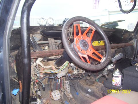 1978 Ford Bronco - The interior of a vehicle shows a custom steering wheel and extensive wiring, suggesting modifications or modification or repair work.