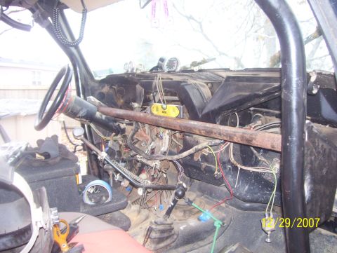1978 Ford Bronco - The dashboard and interior of a vehicle show extensive modifications and exposed wiring.