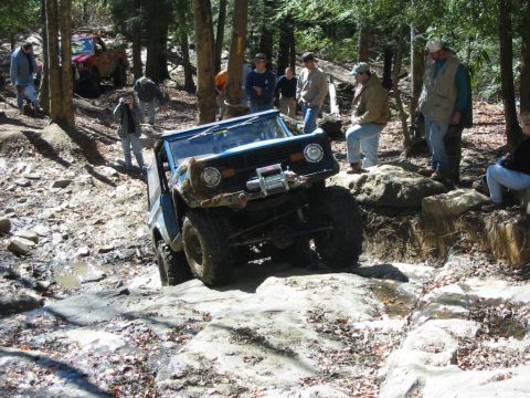 1976 Ford Bronco - Off-road enthusiasts navigate a challenging rocky path in a 1976 Ford Bronco.