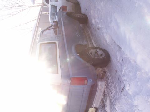 1995 Ford Bronco - Side view of a blue 1995 Ford Bronco parked in the snow.