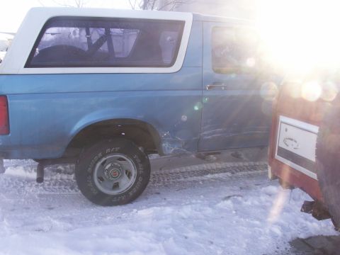 1995 Ford Bronco - A blue 1995 Ford Bronco is parked in a snowy area next to another vehicle.