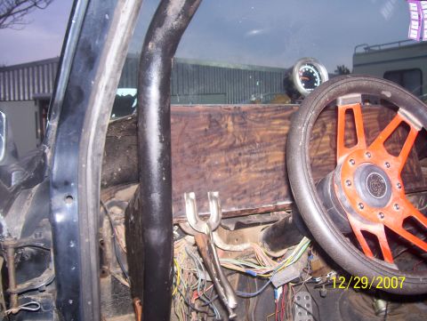 1978 Ford Bronco - Custom dashboard and steering wheel in a vehicle interior, with visible wiring and a gauge.