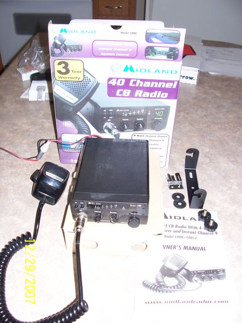 2000 Nissan Xterra - This image shows a Midland 40 Channel CB Radio, model 1000/1001Z, along with its microphone, owner's manual, and mounting accessories.