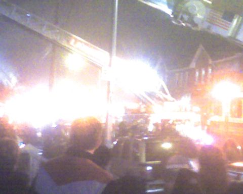 1992 Ford Taurus - Nighttime event with many people and bright lights, obscuring details of any vehicles present.