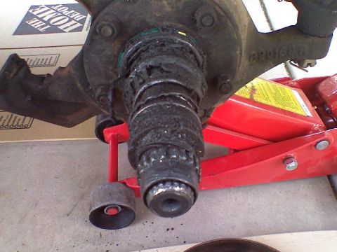 1991 Ford Bronco - This image shows a severely worn wheel bearing assembly, likely needing replacement, supported by a red hydraulic jack.