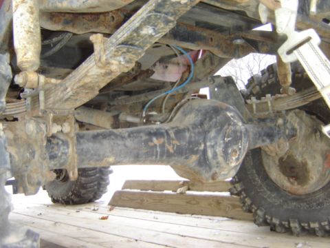 1992 Ford Bronco - Undercarriage view of a vehicle's rear axle and suspension system, showing significant rust and wear.